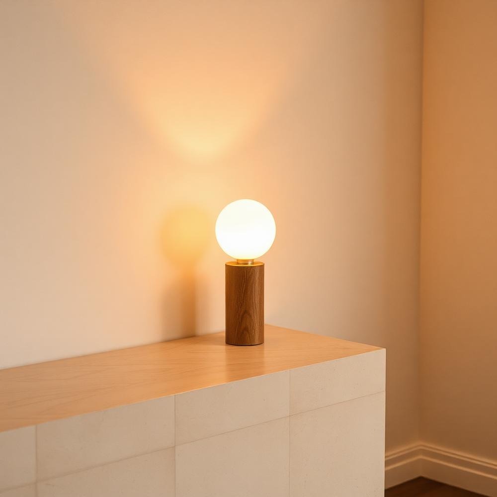 Glowing opal table lamp on a travertine console in a warm minimal room